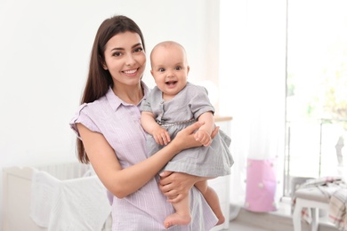 Photo of Young mother with her cute baby girl at home