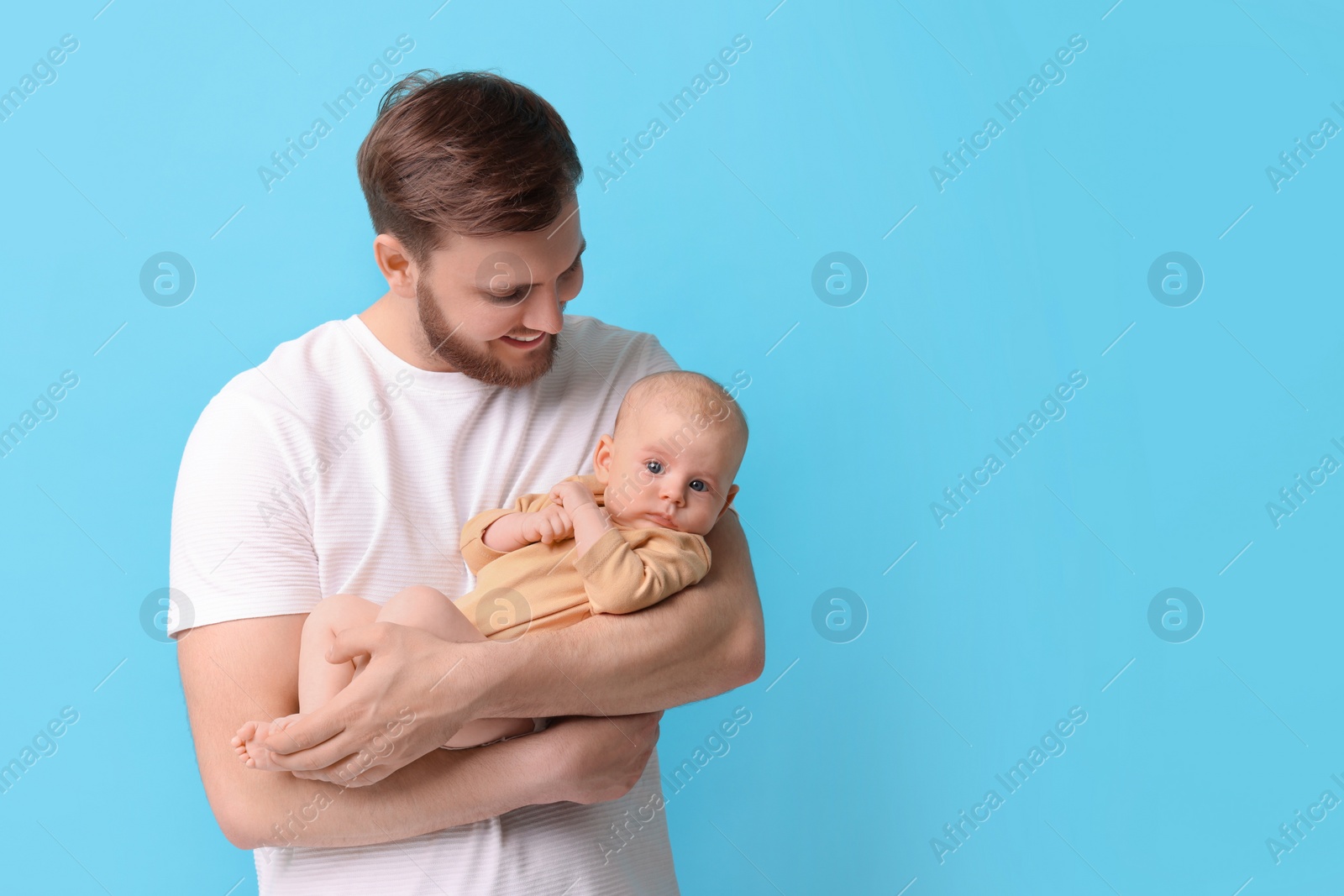 Photo of Father with his cute baby on light blue background, space for text