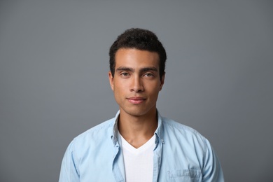 Photo of Handsome young African-American man on grey background