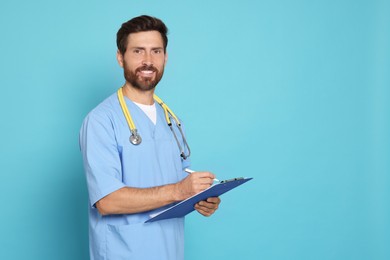 Photo of Happy doctor with stethoscope and clipboard on light blue background. Space for text