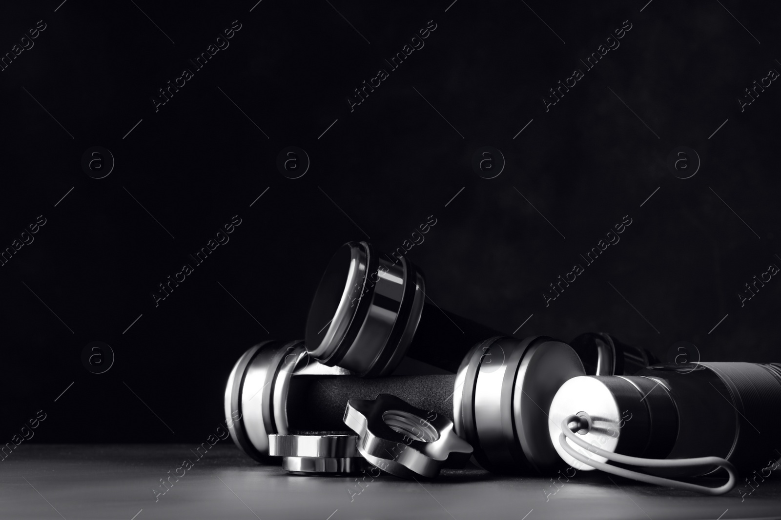 Gym equipment and accessories on floor against dark background. Space for text Photo of Gym equipment and accessories on floor against dark background. Space for text