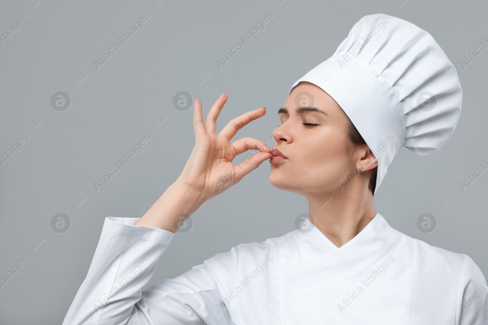 Photo of Female chef showing perfect sign on light grey background