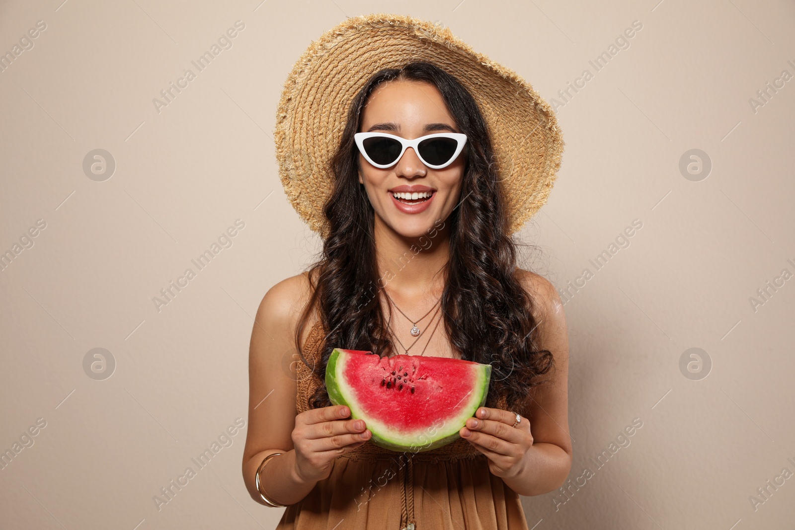 Photo of Beautiful young woman with watermelon on beige background