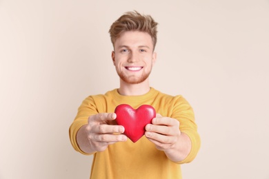 Photo of Portrait of young man with decorative heart on color background