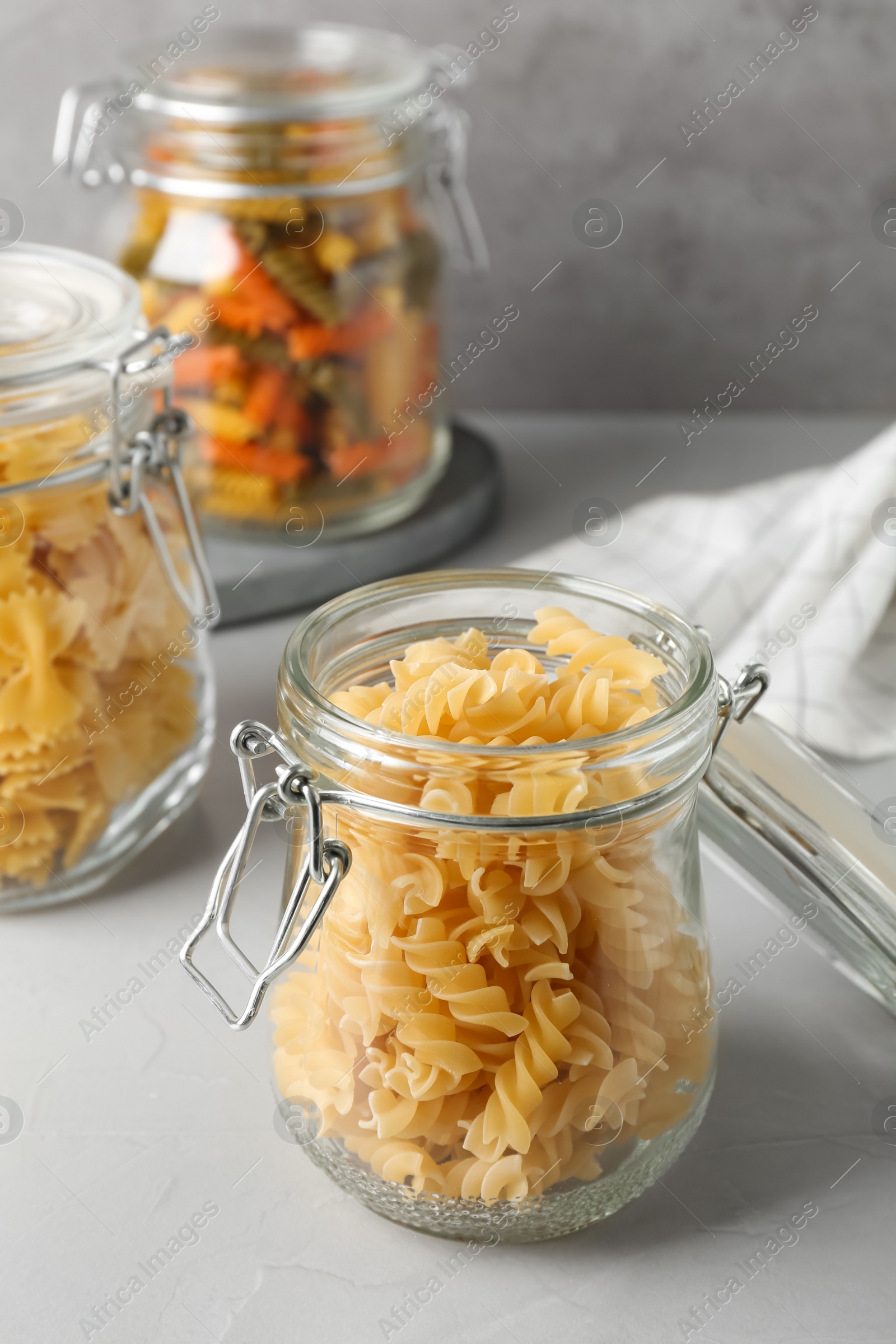 Photo of Pasta in glass jars on grey table