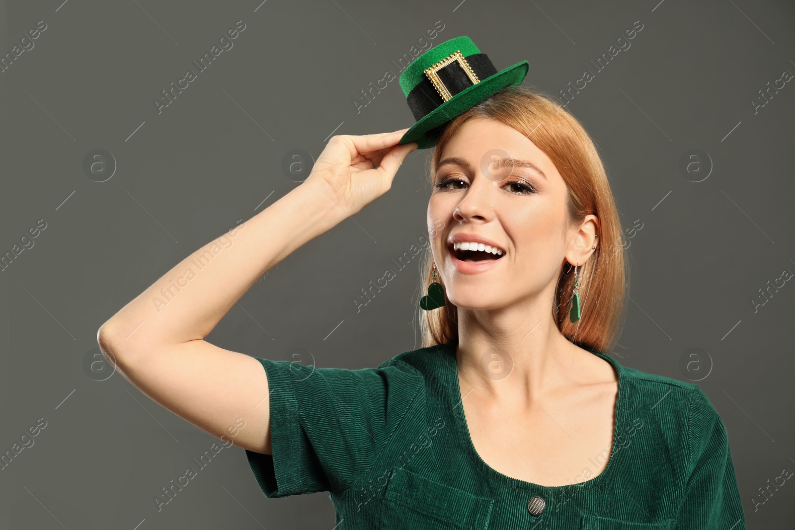 Photo of Young woman with green leprechaun hat on grey background. St. Patrick's Day celebration