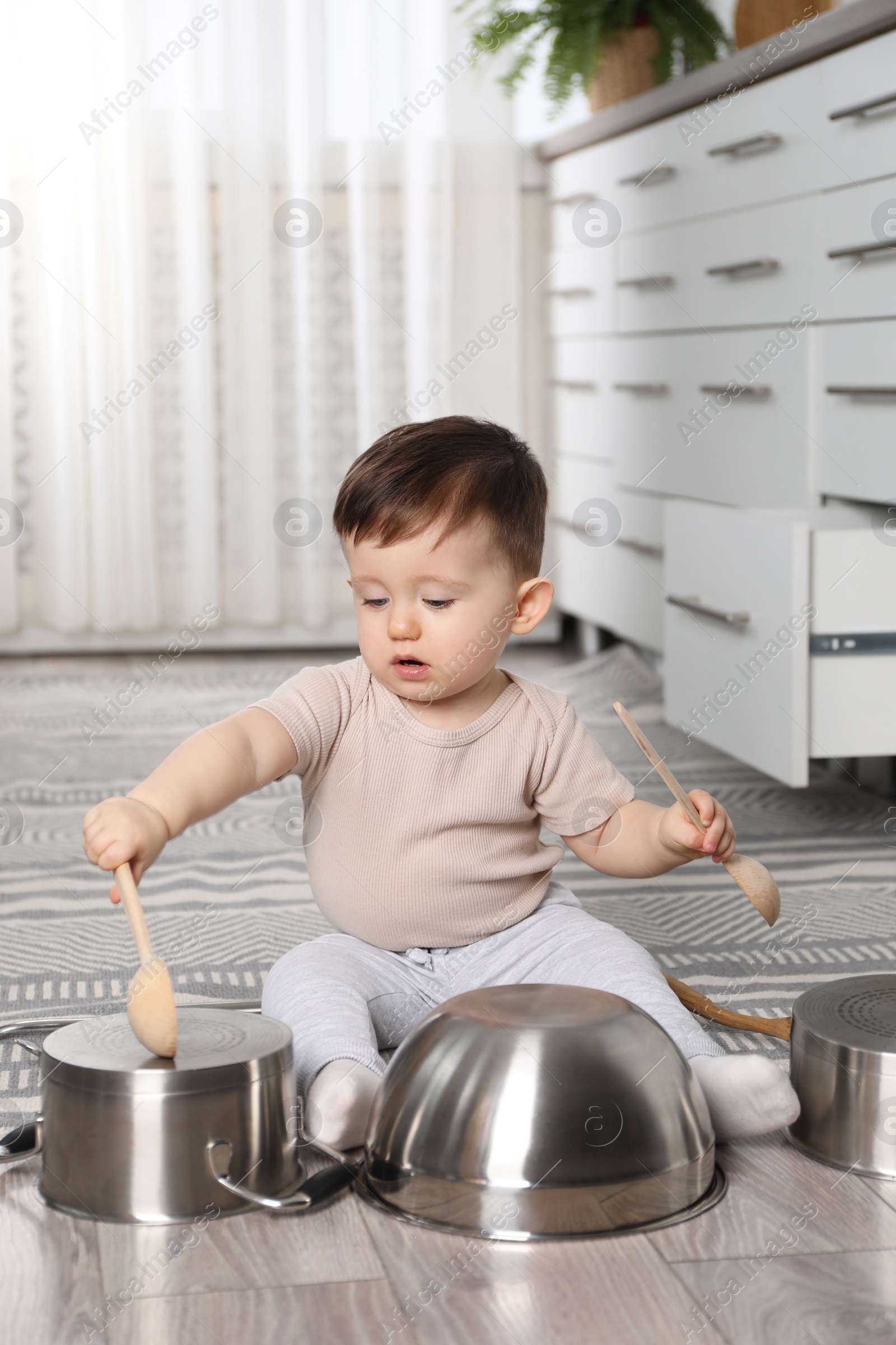 Photo of Cute little boy with cookware at home