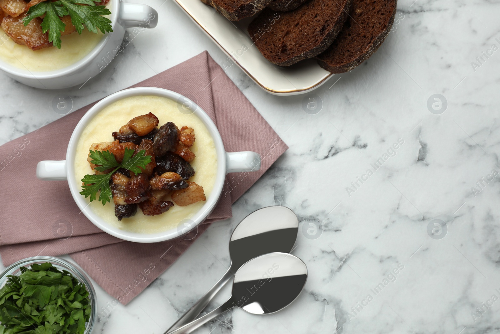 Photo of Potato puree and tasty fried cracklings served on white marble table, flat lay with space for text. Cooked pork lard