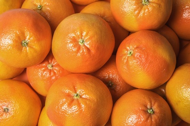 Many whole fresh ripe grapefruits as background, top view