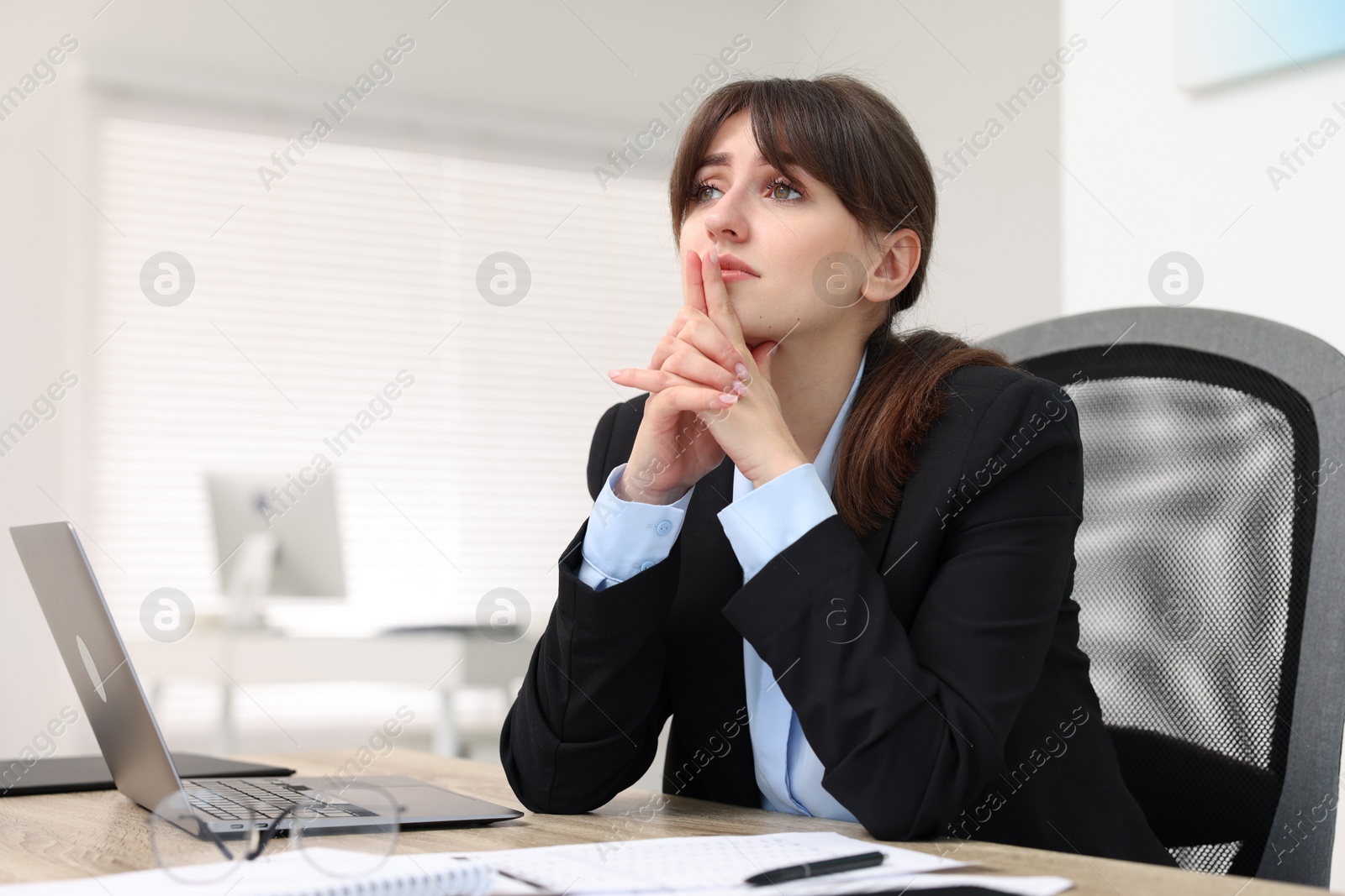 Photo of Overwhelmed woman suffering at table in office