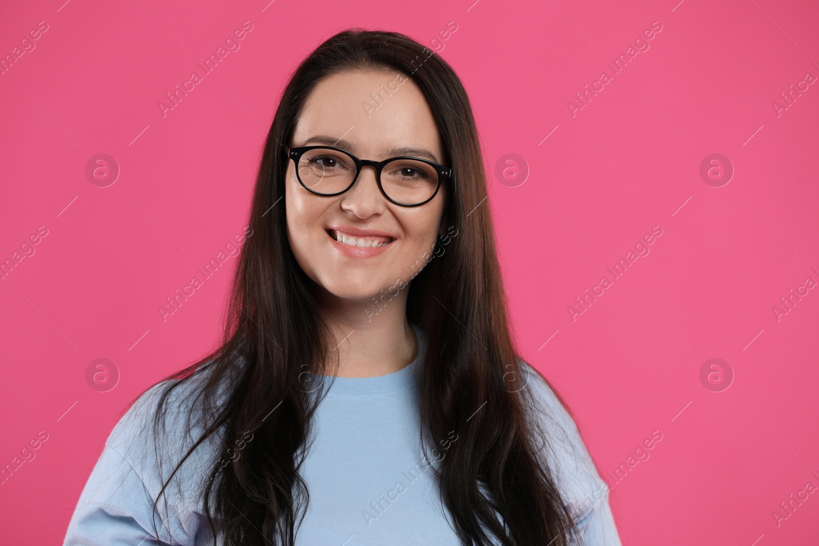 Photo of Beautiful overweight woman in eyeglasses on pink background