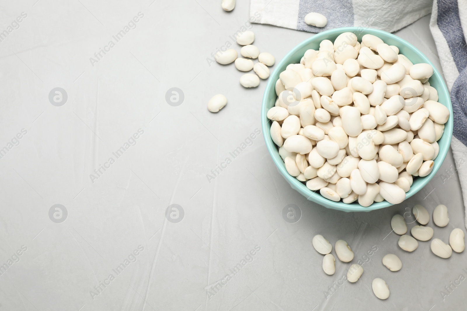 Photo of Raw white beans on light grey table, flat lay. Space for text