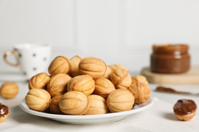 Photo of Homemade walnut shaped cookies with boiled condensed milk on table