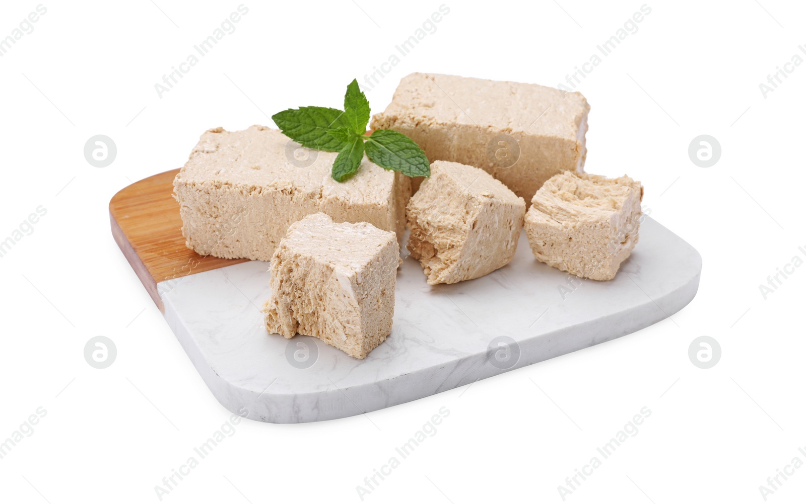 Photo of Board with pieces of tasty halva and mint isolated on white