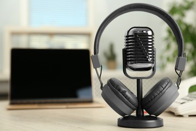 Photo of Microphone and modern headphones on table indoors, space for text