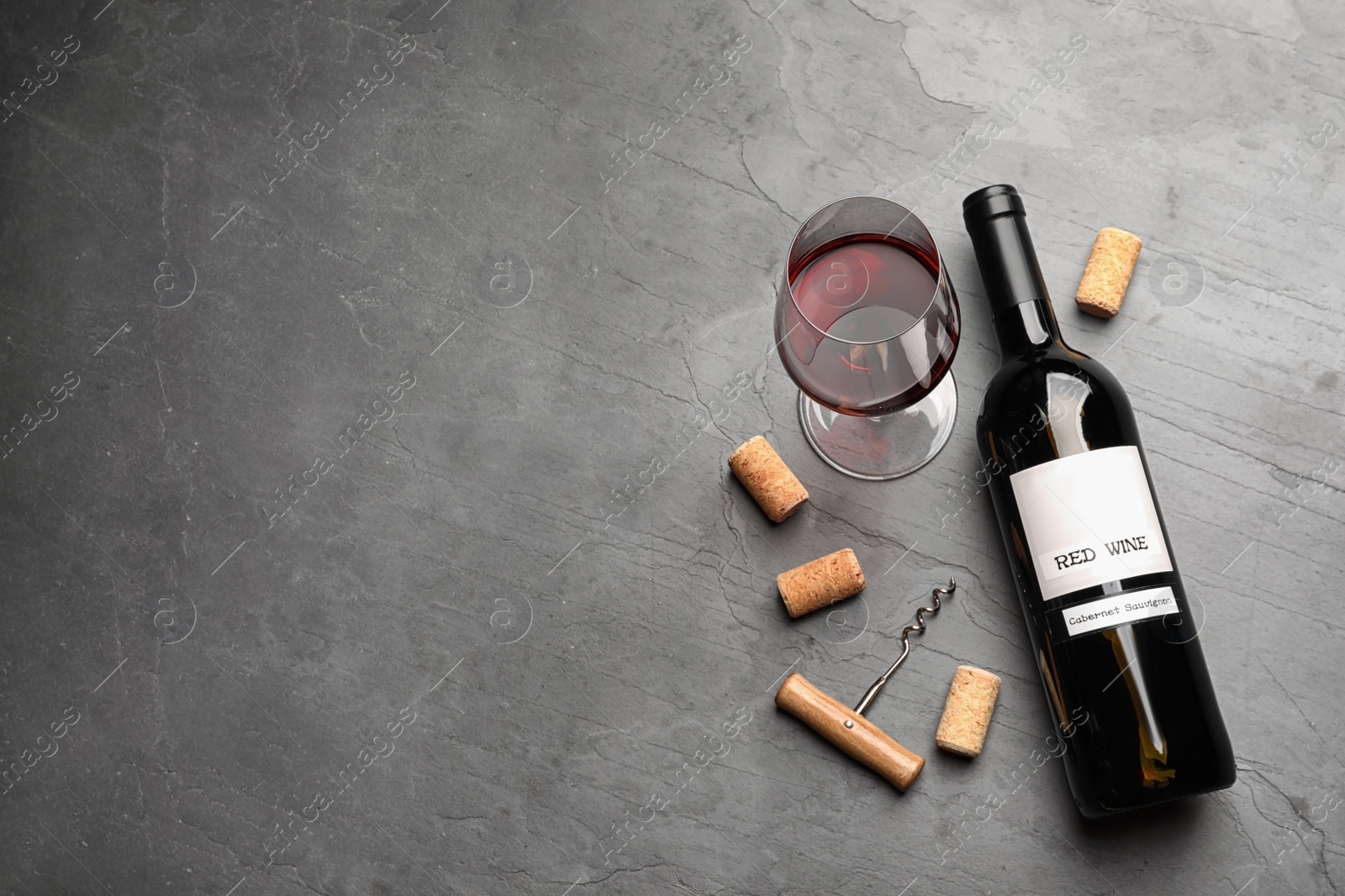 Photo of Flat lay composition with delicious red wine and corks on grey table. Space for text