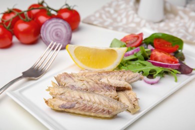 Photo of Delicious canned mackerel fillets served on white table