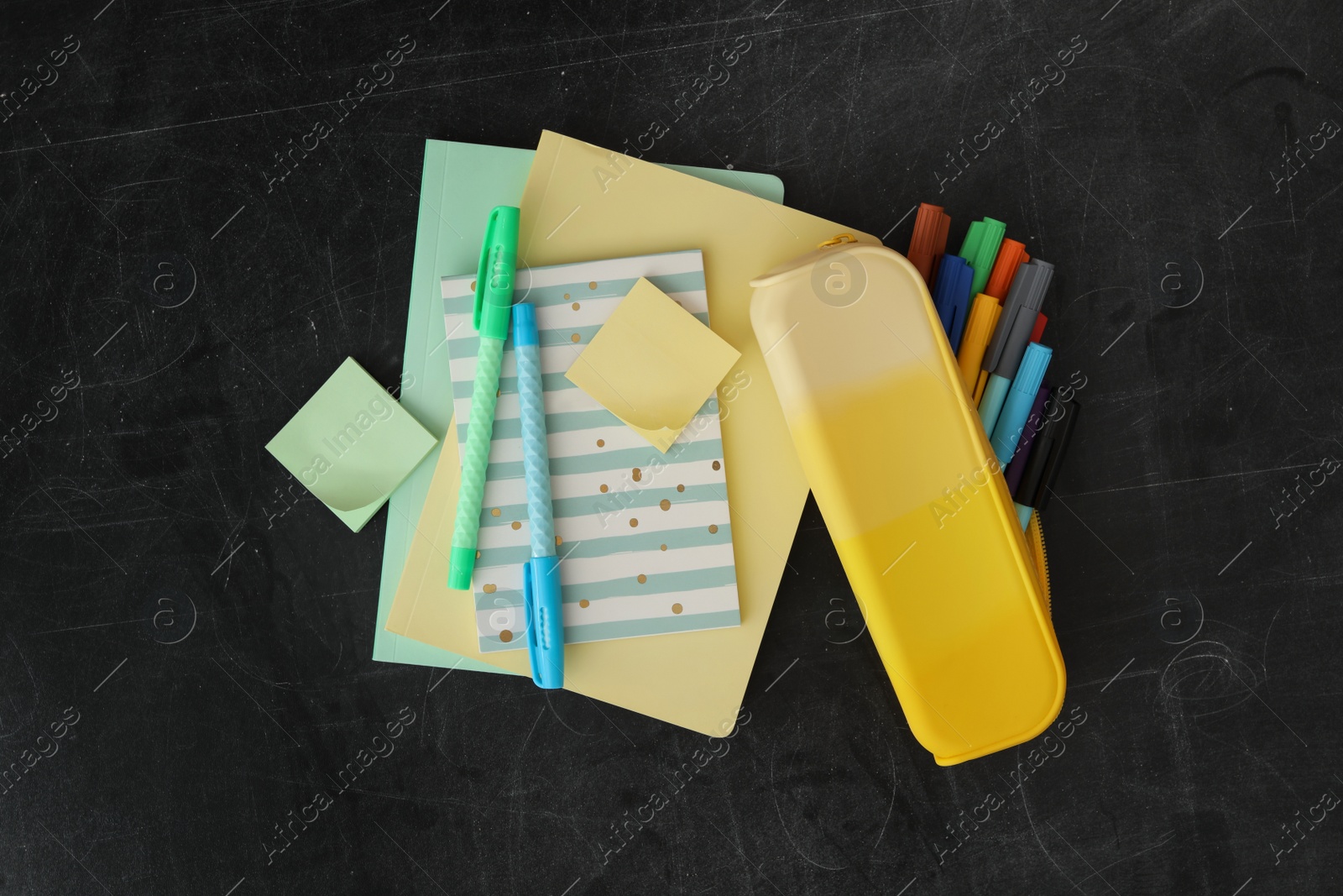 Photo of Different stationery on blackboard, flat lay. Back to school