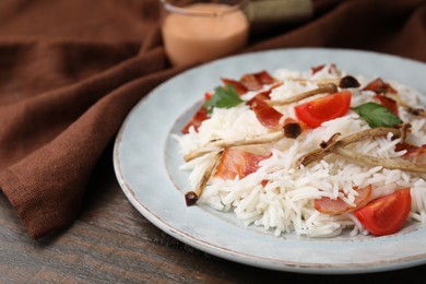 Photo of Delicious rice with bacon, mushrooms and tomatoes on table, closeup