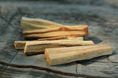 Photo of Palo santo sticks on wooden table, closeup