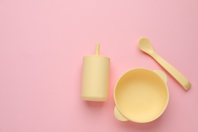 Photo of Set of plastic dishware on pink background, flat lay with space for text. Serving baby food