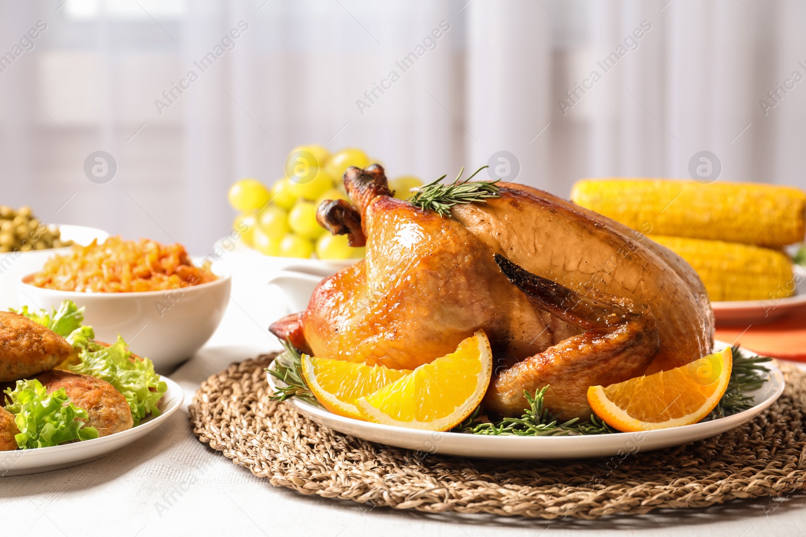 Photo of Delicious roasted turkey with garnish on dinner table