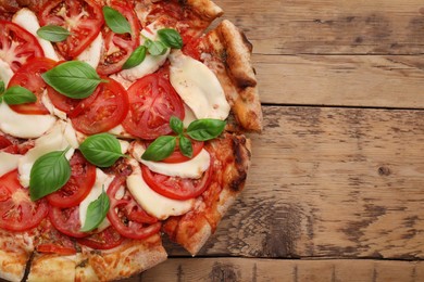Photo of Delicious Caprese pizza on wooden table, top view. Space for text