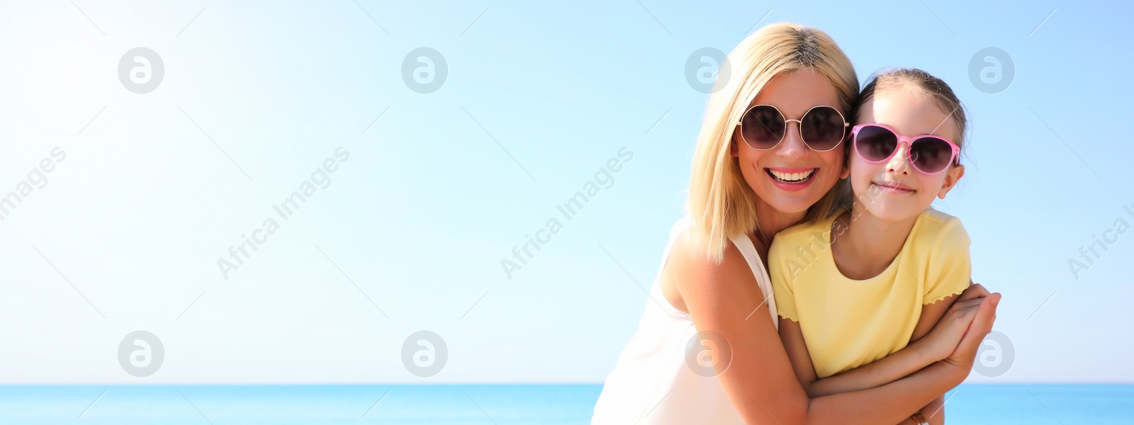 Image of Mother and daughter at beach, space for text. Banner design