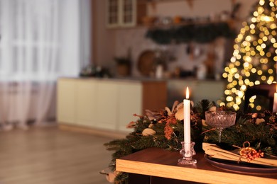 Stylish room with burning candle, Christmas tree and festive decor, space for text. Interior design