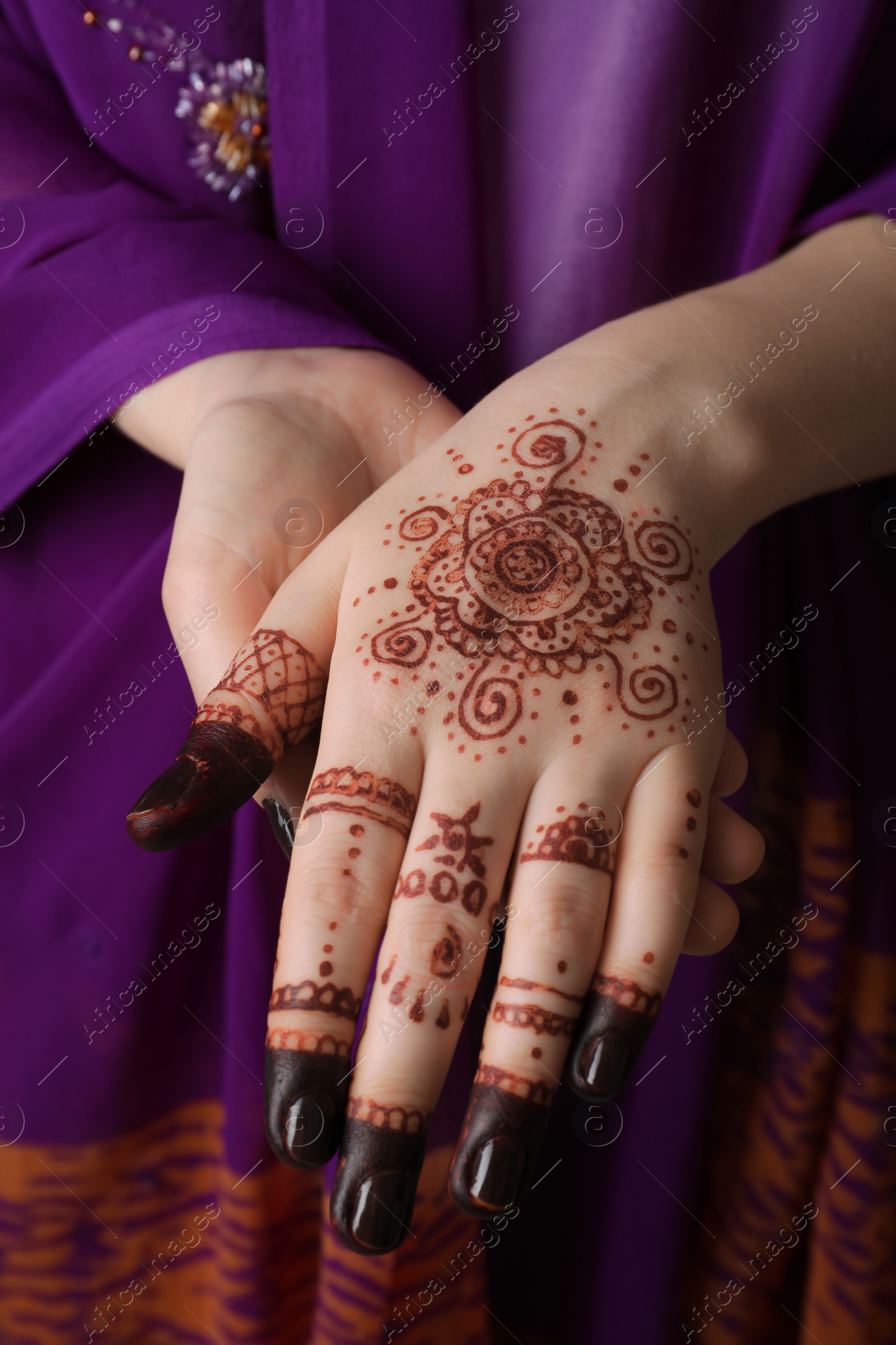 Photo of Woman with henna tattoo on hand, closeup. Traditional mehndi ornament