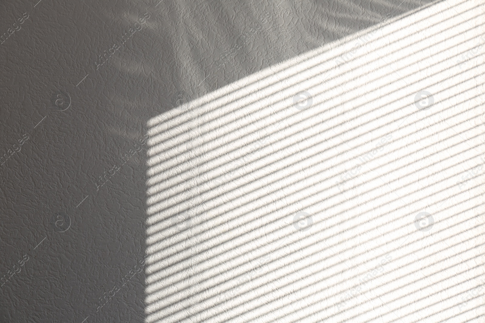 Photo of Light and shadow from window on white wall, space for text