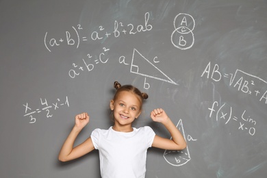 Photo of Little school child and mathematical formulas on grey background