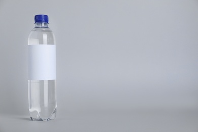 Photo of Plastic bottle with soda water on light background. Space for text