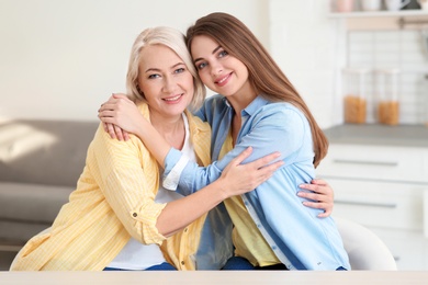 Portrait of young woman with her mature mother at home