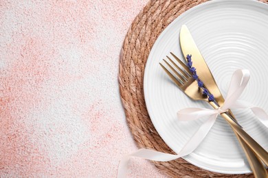 Photo of Cutlery, plate and preserved lavender flower on color textured table, top view. Space for text