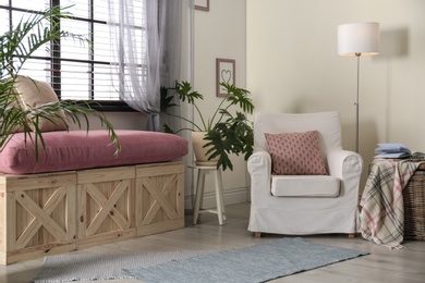 Elegant living room interior with comfortable armchair near window