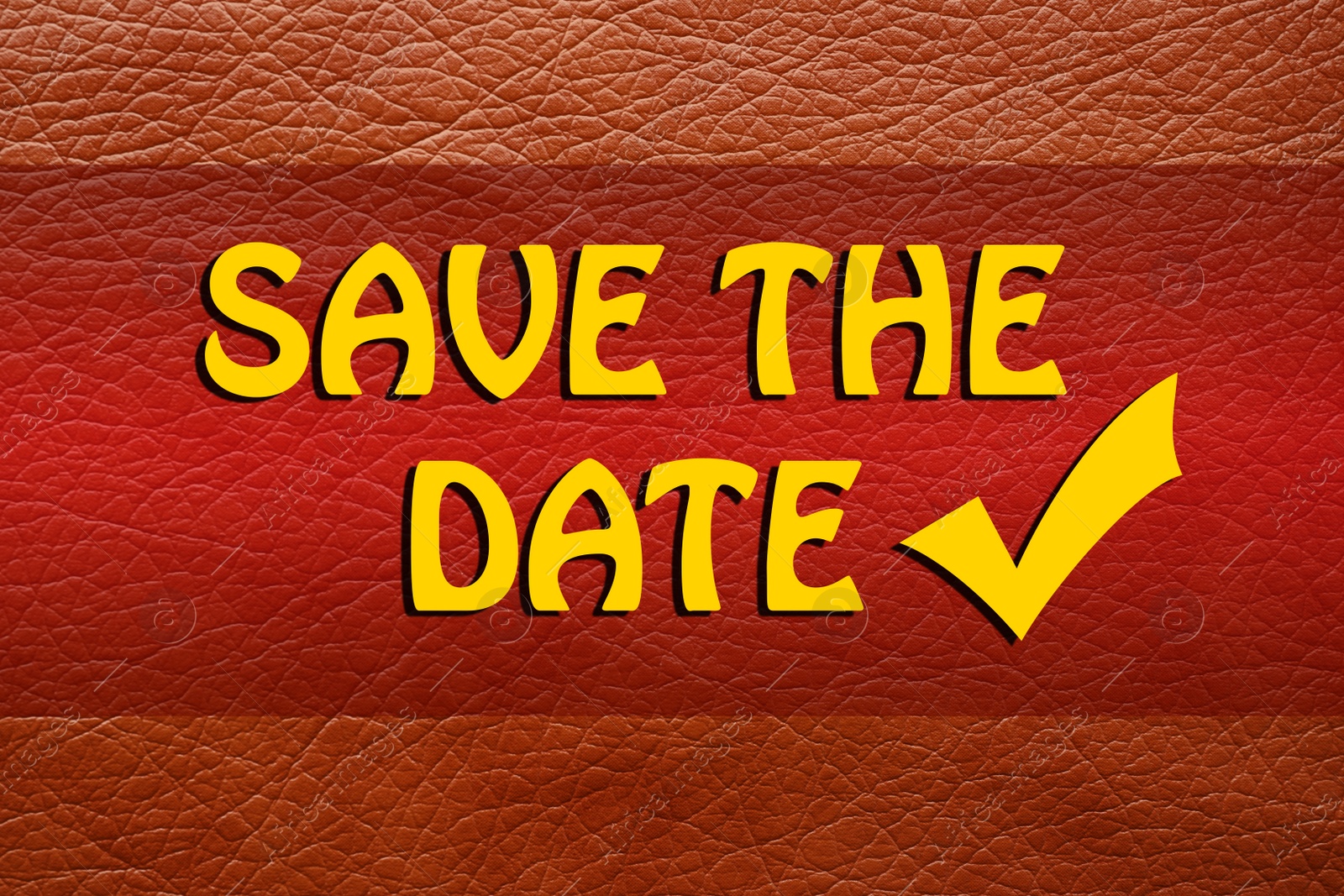 Image of Phrase SAVE THE DATE on orange leather, top view  