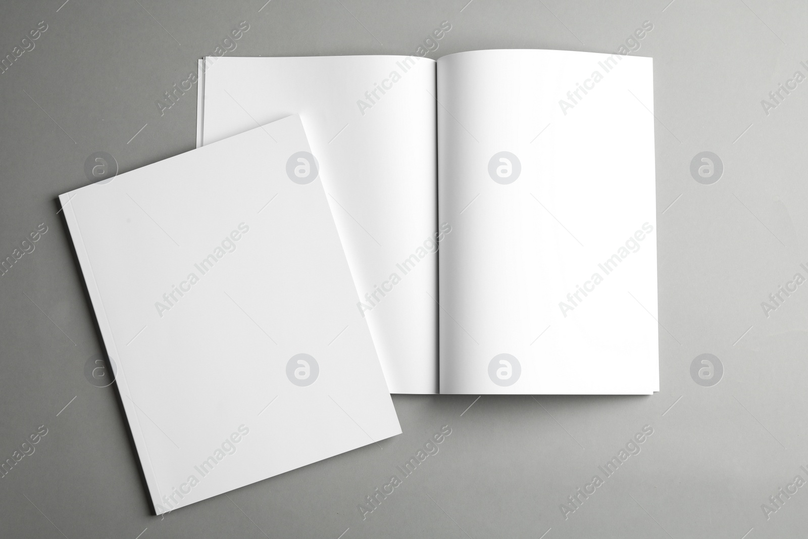 Photo of Open and closed blank brochures on grey background, top view. Mock up for design