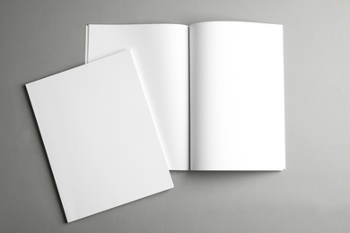 Photo of Open and closed blank brochures on grey background, top view. Mock up for design