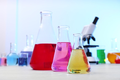 Photo of Different conical flasks with samples on table in chemistry laboratory
