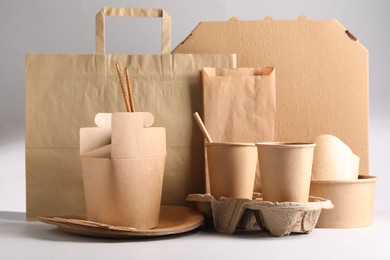 Eco friendly food packaging. Paper containers, tableware and bag on light background