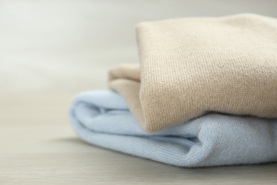 Cashmere clothes on wooden table, closeup view