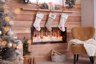 Photo of Fireplace with Christmas stockings in room. Festive interior
