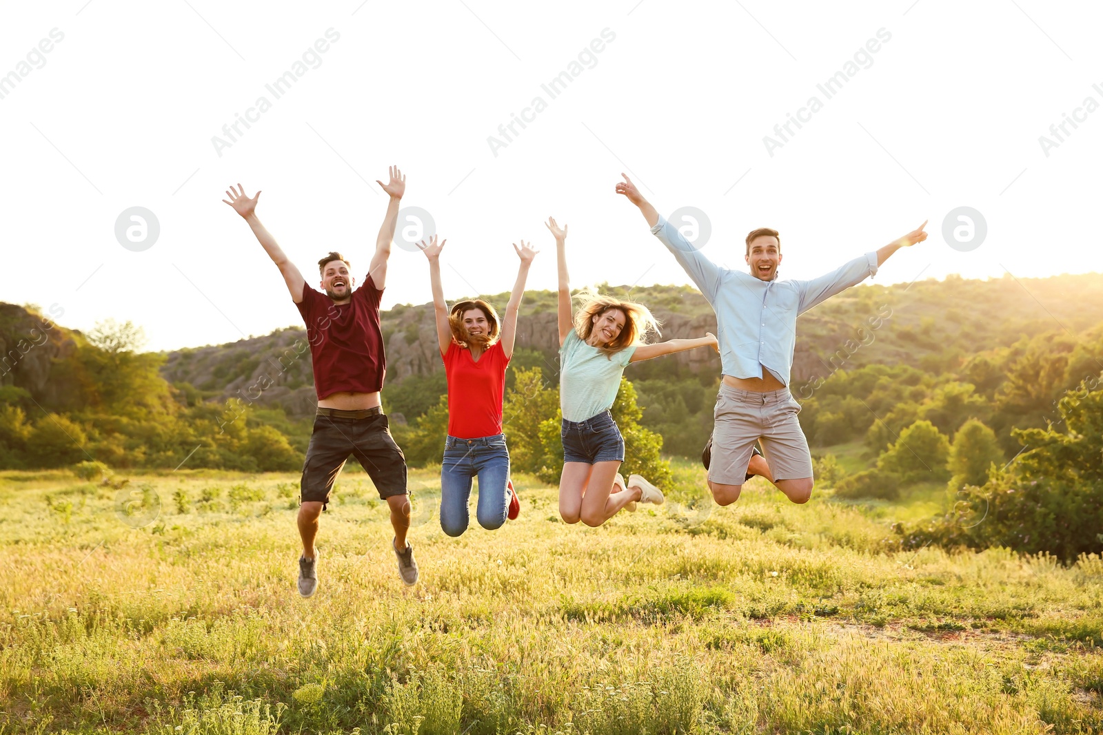 Photo of Happy young people jumping in wilderness. Camping season