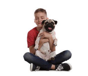 Boy hugging his cute pug on white background