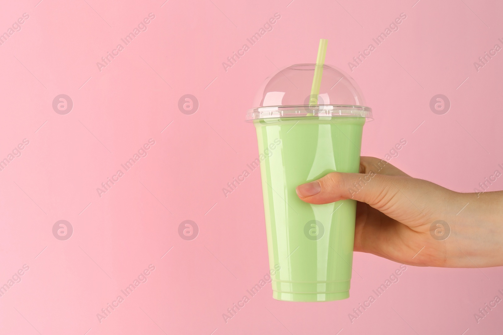 Photo of Woman with plastic cup of tasty smoothie on pink background, closeup. Space for text