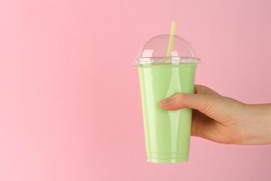 Photo of Woman with plastic cup of tasty smoothie on pink background, closeup. Space for text