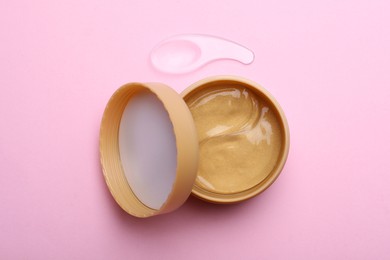 Photo of Package of under eye patches on pink background, flat lay. Cosmetic product