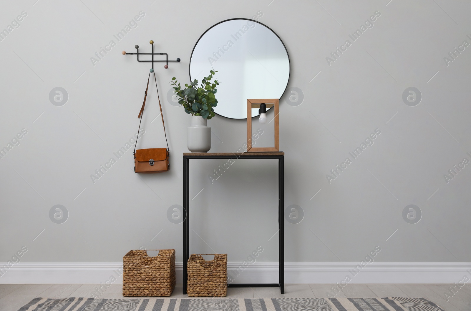 Photo of Light hallway with stylish console table and mirror. Interior design