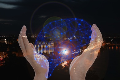 Man holding digital image of brain in hands and night cityscape on background, closeup. Machine learning concept 